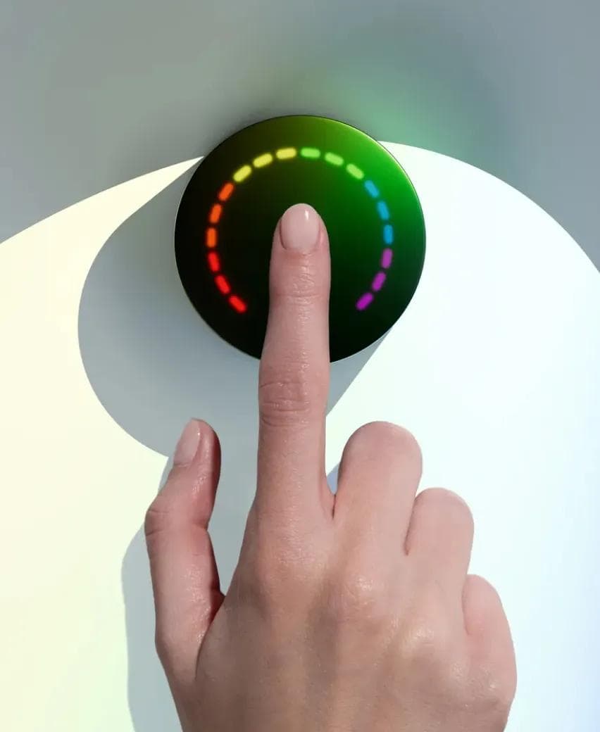 A fingertip on the Prysm iO scanner with its ring of light lit up mid-reading
